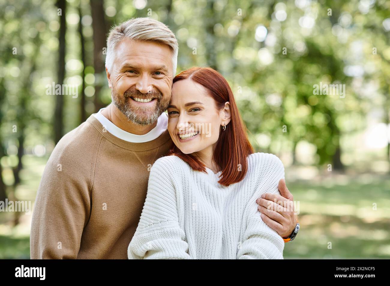 Ein Mann und eine Frau teilen ein Lächeln in einem Park. Stockfoto