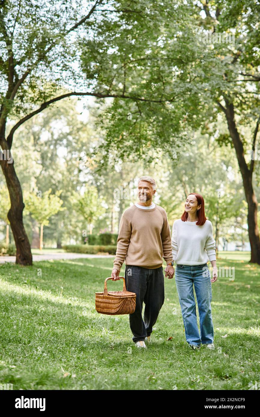 Ein Paar, lässig gekleidet, friedlich durch einen Park spazieren. Stockfoto