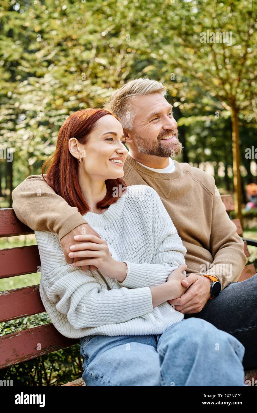 Ein Mann und eine Frau genießen einen friedlichen Moment auf einer Bank im Park. Stockfoto