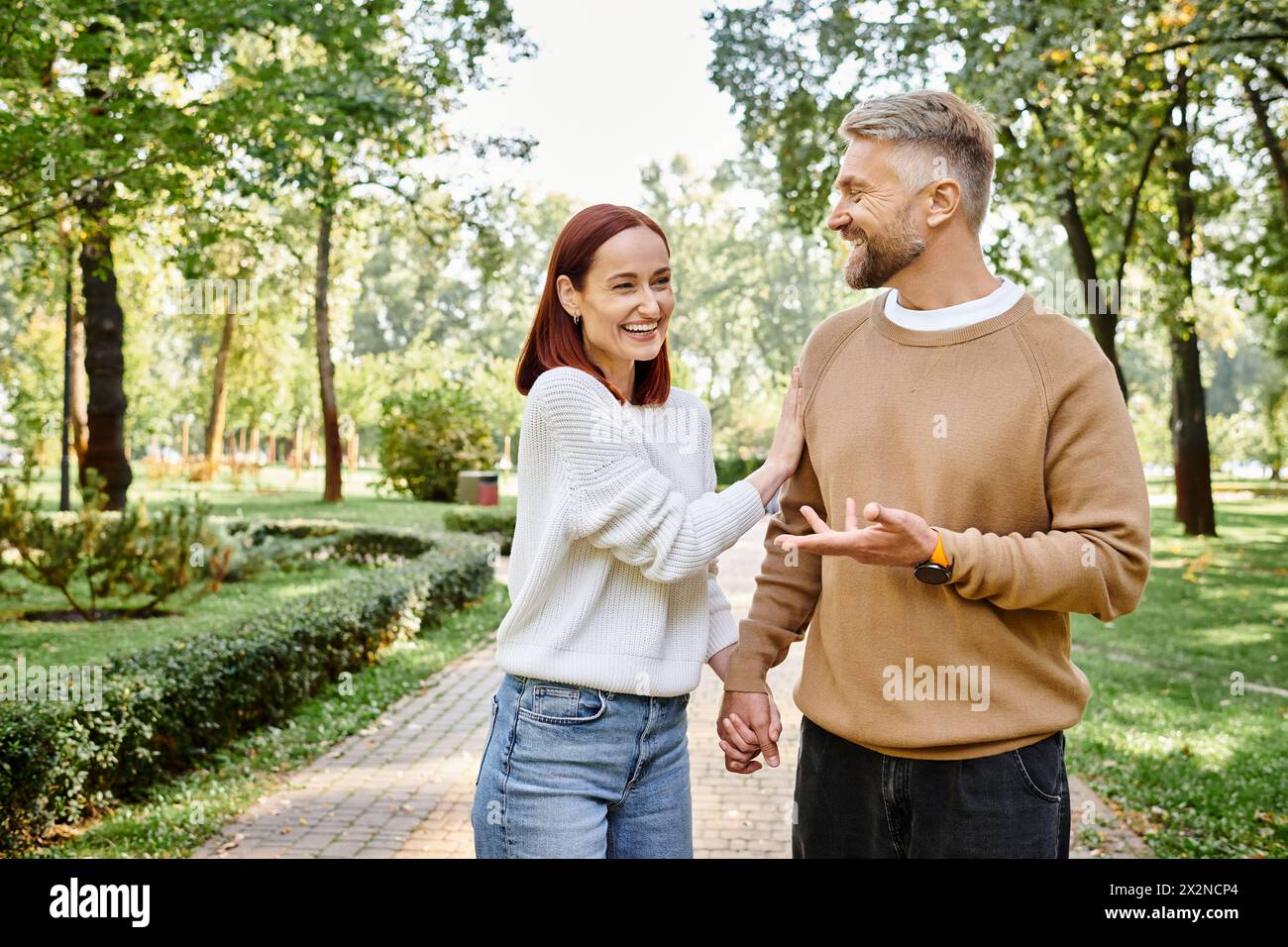 Erwachsene lieben Paare, die durch einen friedlichen Park laufen. Stockfoto