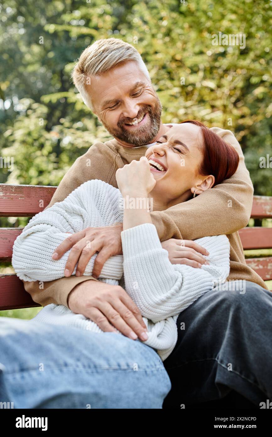 Mann und Frau sitzen friedlich zusammen auf einer ruhigen Bank im Park. Stockfoto