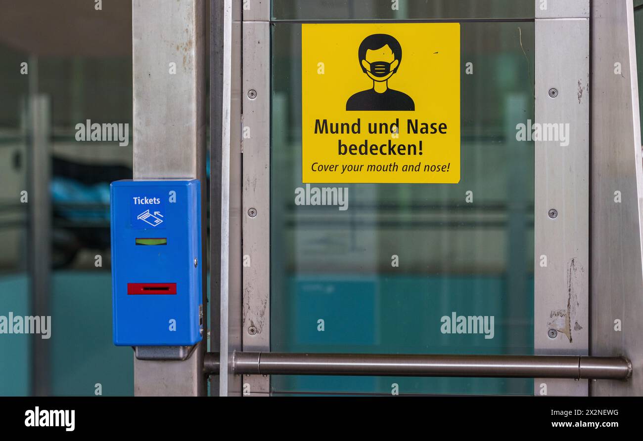 Bei einer U-Bahnstation steht ein Entwertungsautomat wo Tickets für den öffentlichen Verkehr entwertet werden können. Gleichzeitig hängt ein Hinweis, Stockfoto