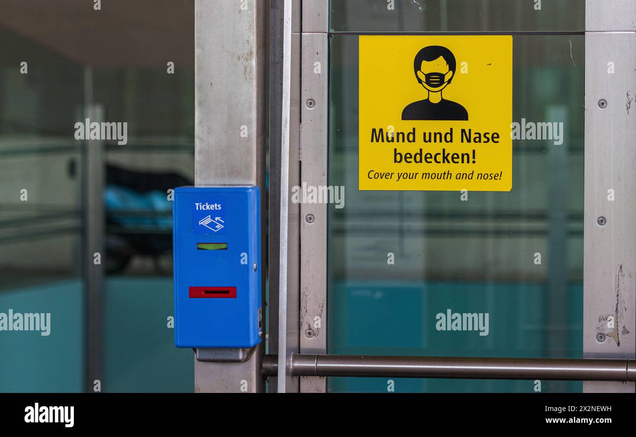 Bei einer U-Bahnstation steht ein Entwertungsautomat wo Tickets für den öffentlichen Verkehr entwertet werden können. Gleichzeitig hängt ein Hinweis, Stockfoto