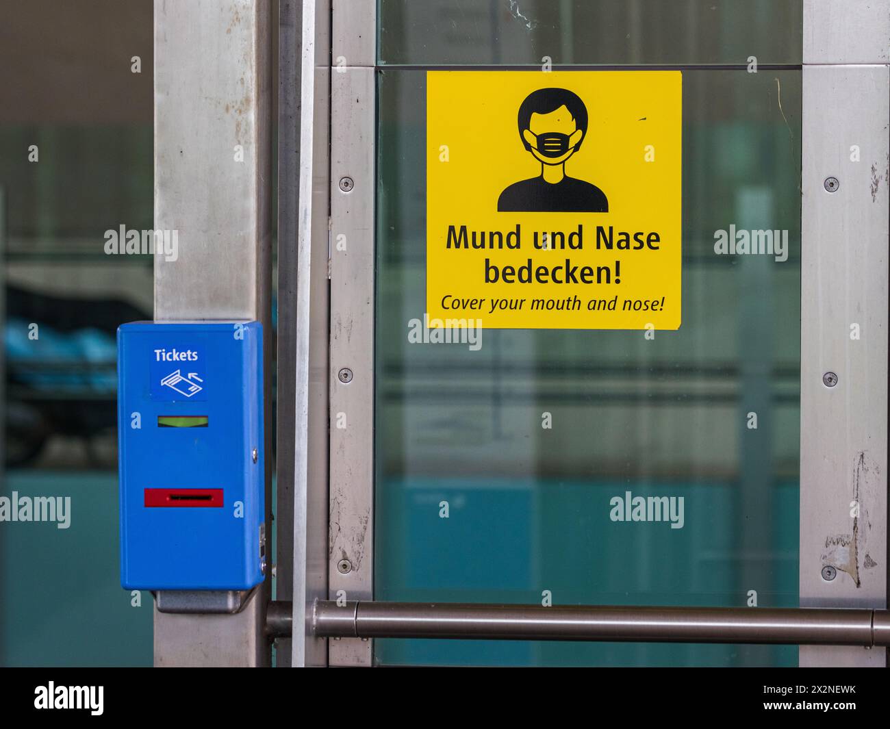 Bei einer U-Bahnstation steht ein Entwertungsautomat wo Tickets für den öffentlichen Verkehr entwertet werden können. Gleichzeitig hängt ein Hinweis, Stockfoto