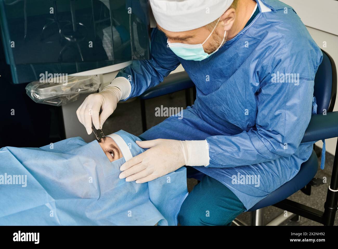 Chirurg im Kleid führt Laser-Sehkorrektur-Operationen am Kopf des Patienten durch. Stockfoto