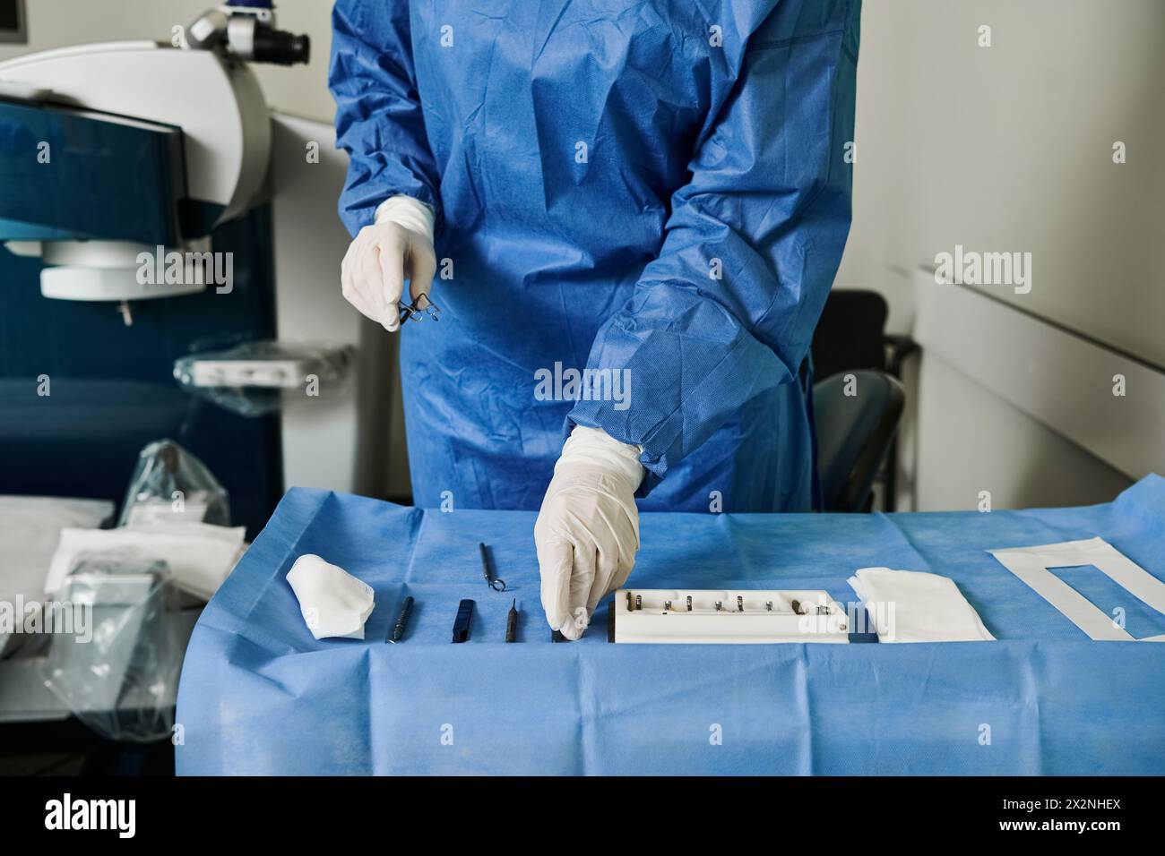 Eine Frau in blauem Anzug und weißen Handschuhen, die in der Arztpraxis eine Laser-Sehkorrektur erhält. Stockfoto
