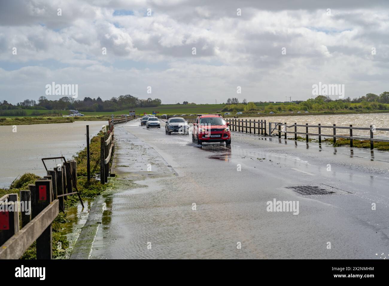 Verkehr über den Strood nach Mersea Island Essex. Der Damm ist bei Hochwasser überflutet. Stockfoto