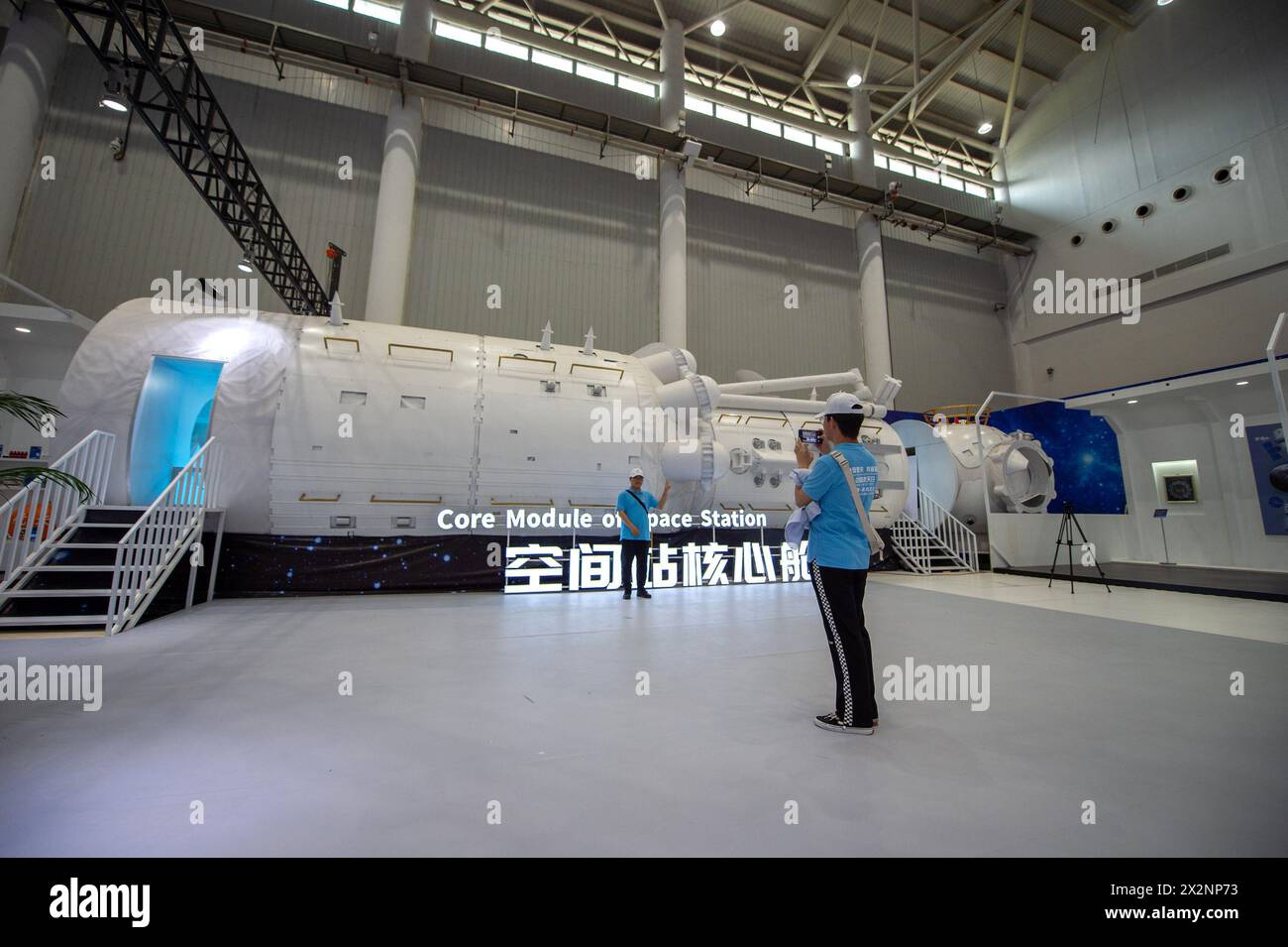 (240423) -- WUHAN, 23. April 2024 (Xinhua) -- Ein Besucher posiert für ein Foto mit einem Modell des Kernmoduls der Raumstation auf einer Ausstellung über Luft- und Raumfahrt in Wuhan, Zentralchinas Provinz Hubei, 23. April 2024. Im Rahmen der diesjährigen Feier des Weltraumtags Chinas zeigt die Ausstellung die Popularisierung der Wissenschaft und die Errungenschaften der Luft- und Raumfahrtindustrie und bietet Besuchern einen umfassenden Blick auf die chinesische Luft- und Raumfahrtindustrie und ihre Errungenschaften in den letzten Jahren. Die Ausstellung ist am Mittwochnachmittag mit dem Ausstellungsbereich für die Errungenschaften der Luft- und Raumfahrtindustrie für die Öffentlichkeit zugänglich Stockfoto