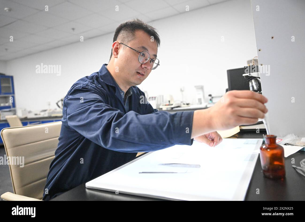 (240423) -- TIANJIN, 23. April 2024 (Xinhua) -- Gao Xuemiao bereitet Agent für Experimente im Labor der Tianjin-Bibliothek in der nordchinesischen Gemeinde Tianjin vor, 18. April 2024. Die Bibliothek Tianjin beherbergt eine Sammlung von 590.000 antiken Büchern und hat seit über 70 Jahren alte Bücher restauriert. Gao Xuemiao, 38, leitet das Restaurierungsteam der Bibliothek. Er ist der erste Restaurierungsexperte mit einem Hintergrund in Chemie seit der Gründung der Abteilung im Jahr 1978. Heutzutage wird die Restaurierung von alten Büchern zunehmend als interdisziplinärer Prozess angesehen. Die Incorpora Stockfoto