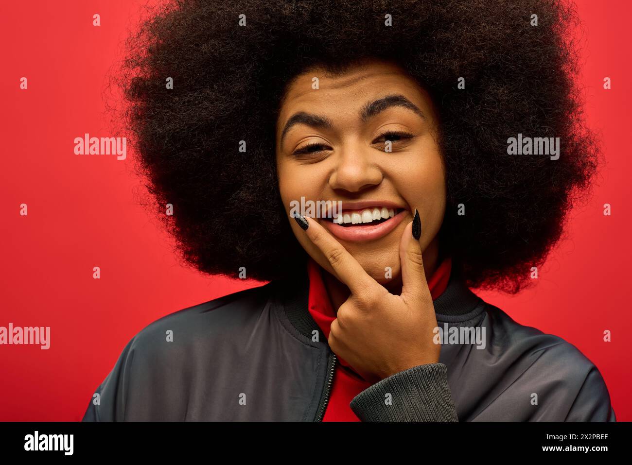 Die stilvolle afroamerikanische Frau lächelt nach der Kamera. Stockfoto