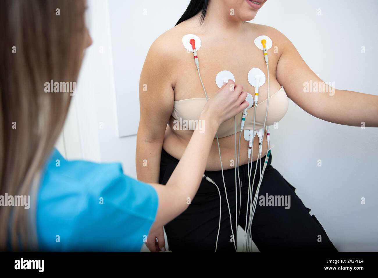 Adipöse junge Frau wird während eines Laufband-Stresstests von einem medizinischen Fachpersonal überwacht. Stockfoto