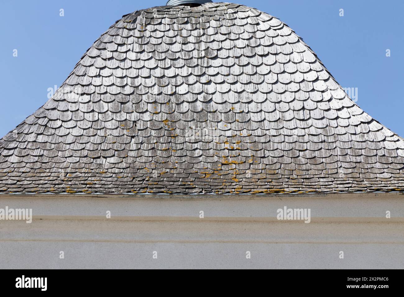 Alte Holzschindeln auf dem Dach der Hütte. Blauer Himmel im Hintergrund. Nahaufnahme. Stockfoto Alte Holzschindeln auf dem Dach der Hütte. Blauer Himmel im Hintergrund. Nahaufnahme. Stockfoto