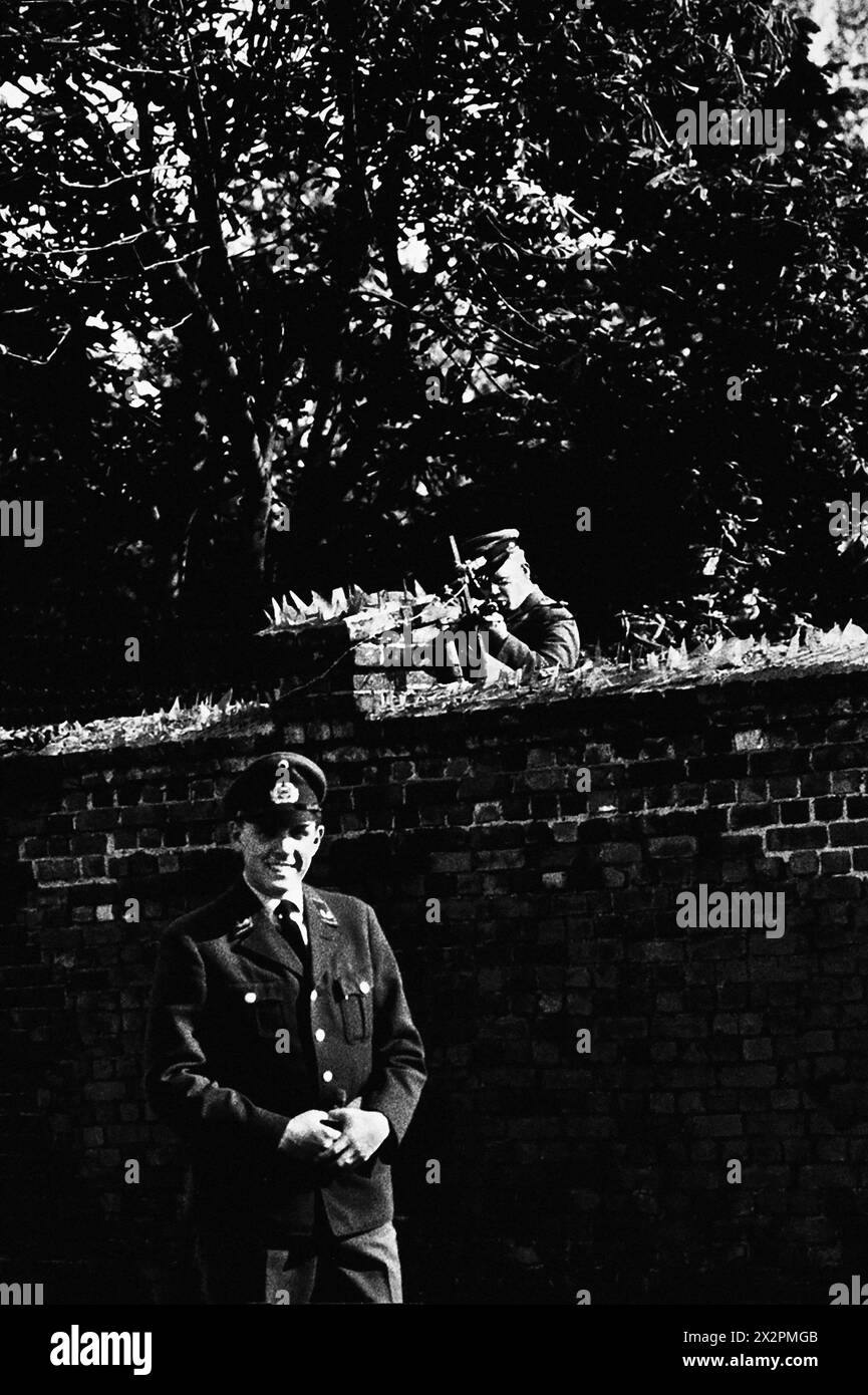 Porträt eines West-Berliner Offiziers in Uniform an der Berliner Mauer, während der Ost-Berliner Soldat eine Punktpistole über der Mauer auf ihn legt, Ost- und Westdeutschland, Toni Frissell, Oktober 1961 Stockfoto
