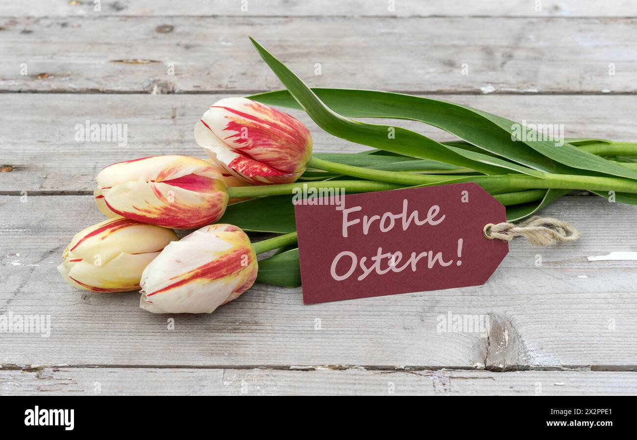 Grußkarte mit roten, gelben und weißen Tulpen und deutschem Text: Happy Easter Stockfoto