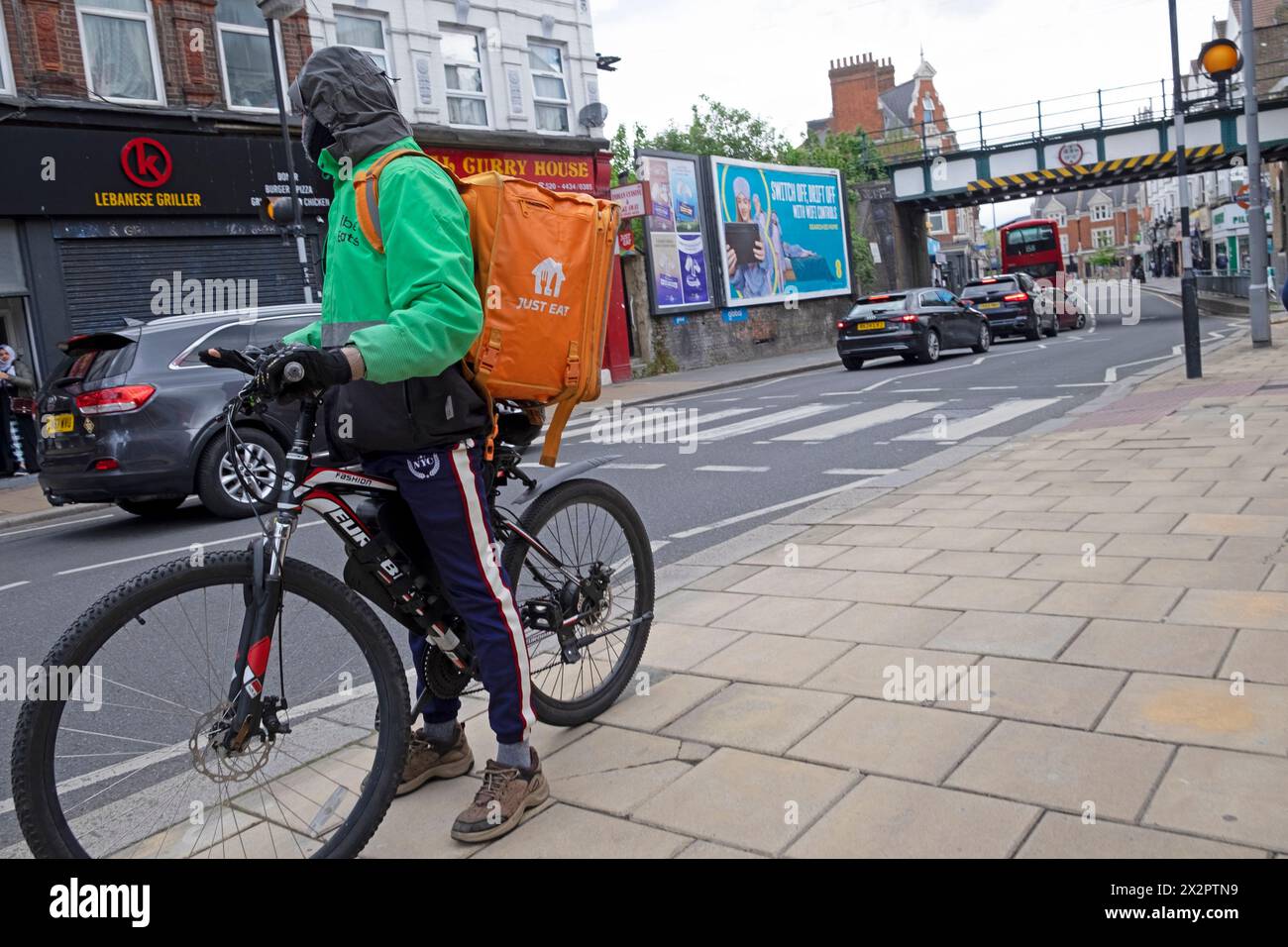 Einfach essen Essenszustellung Kurier Radfahrer steht auf der Straße auf dem Fahrrad in der Straße London England Großbritannien 2024 KATHY DEWITT Stockfoto