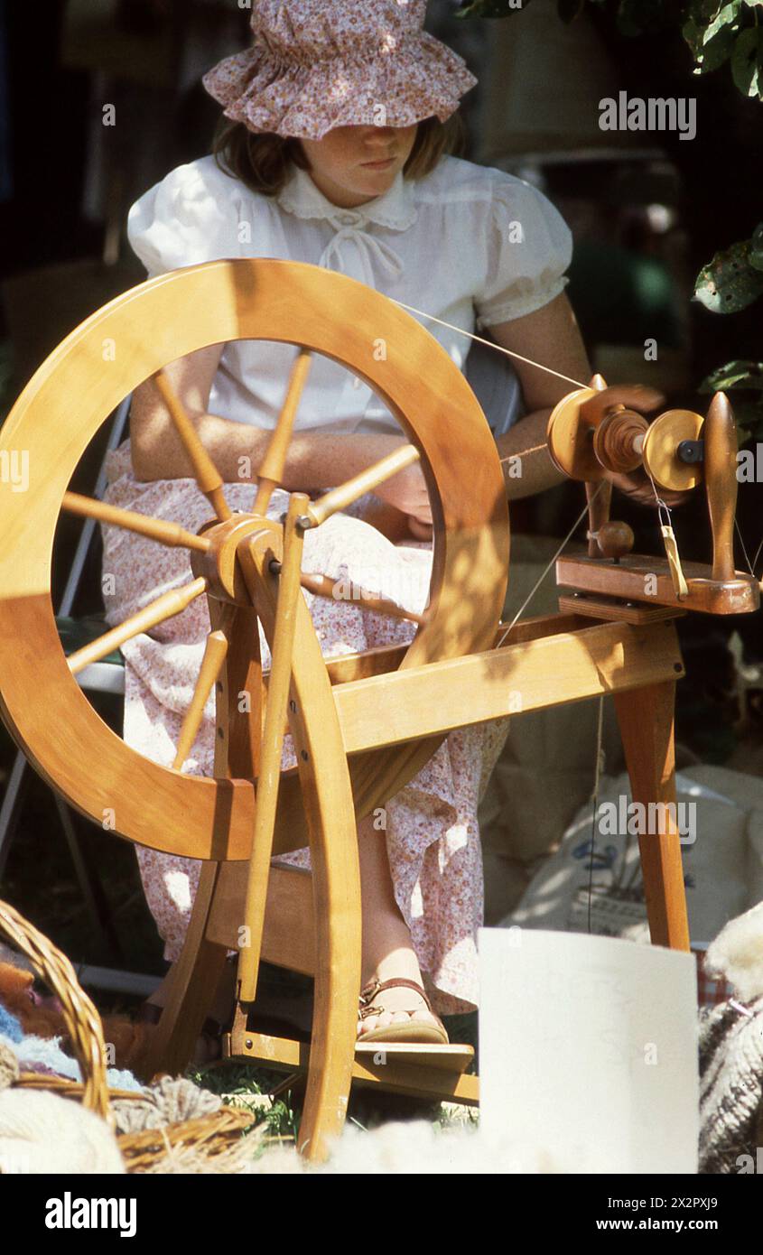 Connecticut, USA, 1982. Frau, die ein drehendes Rad benutzt; historische Nachstellung auf einer Kulturmesse. Stockfoto