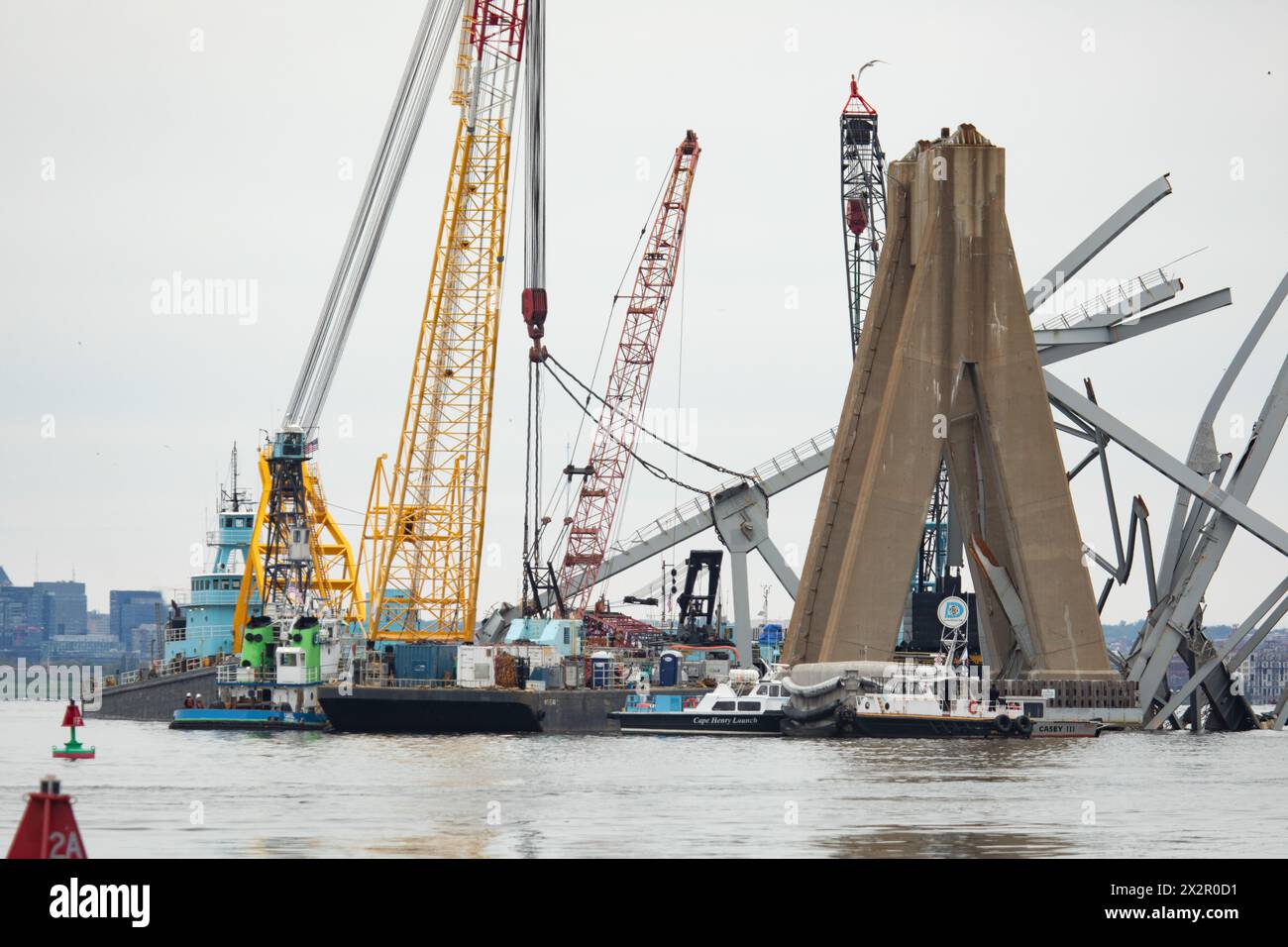 Dundalk, Vereinigte Staaten Von Amerika. April 2024. Dundalk, Vereinigte Staaten von Amerika. 20. April 2024. Bergungskähne entfernen die Wrackteile der eingestürzten Francis Scott Key Bridge, um den Betrieb im Hafen von Baltimore wiederherzustellen, der am 21. April 2024 durch den Kanal Fort McHenry führt, in der Nähe von Dundalk, Maryland. Die Brücke wurde am 26. März von dem 984-Fuß-Containerschiff MV Dali getroffen und stürzte zusammen, wobei sechs Arbeiter ums Leben kamen. Quelle: Christopher Rosario/U.S. Army/Alamy Live News Stockfoto