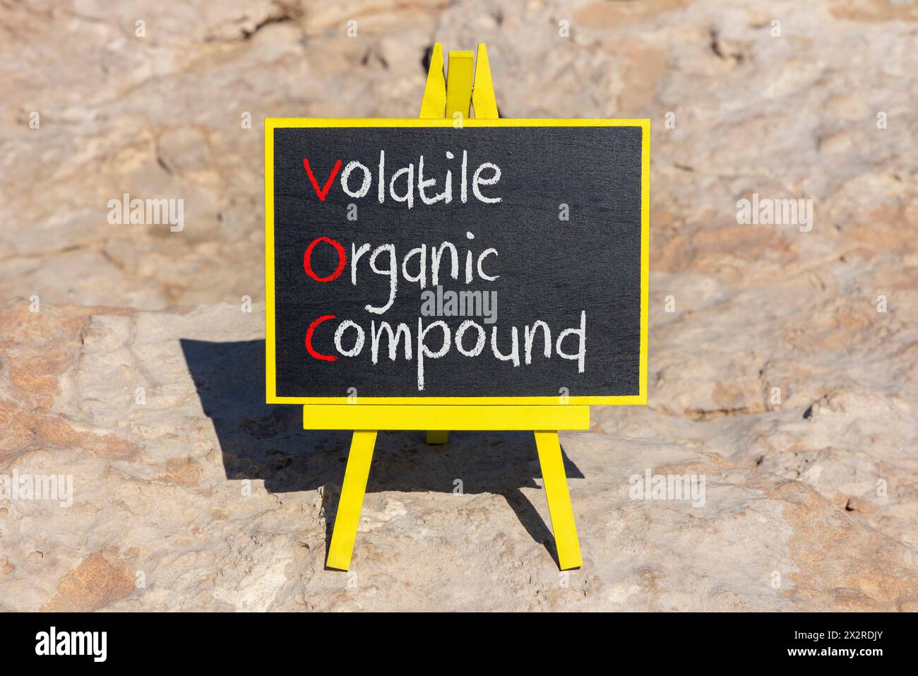 VOC-Symbol für flüchtige organische Verbindungen. Konzeptworte VOC flüchtige organische Verbindung auf schöner gelber Tafel. Wunderschöner Steinhintergrund. Unternehmen Stockfoto
