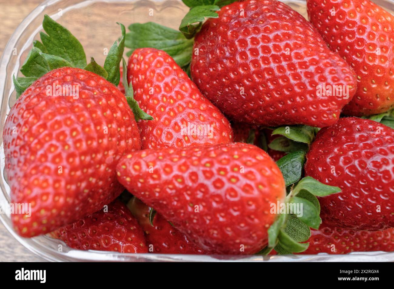 ESSEN; Erdbeeren in einer Plastikkiste auf einem Holztisch Stockfoto
