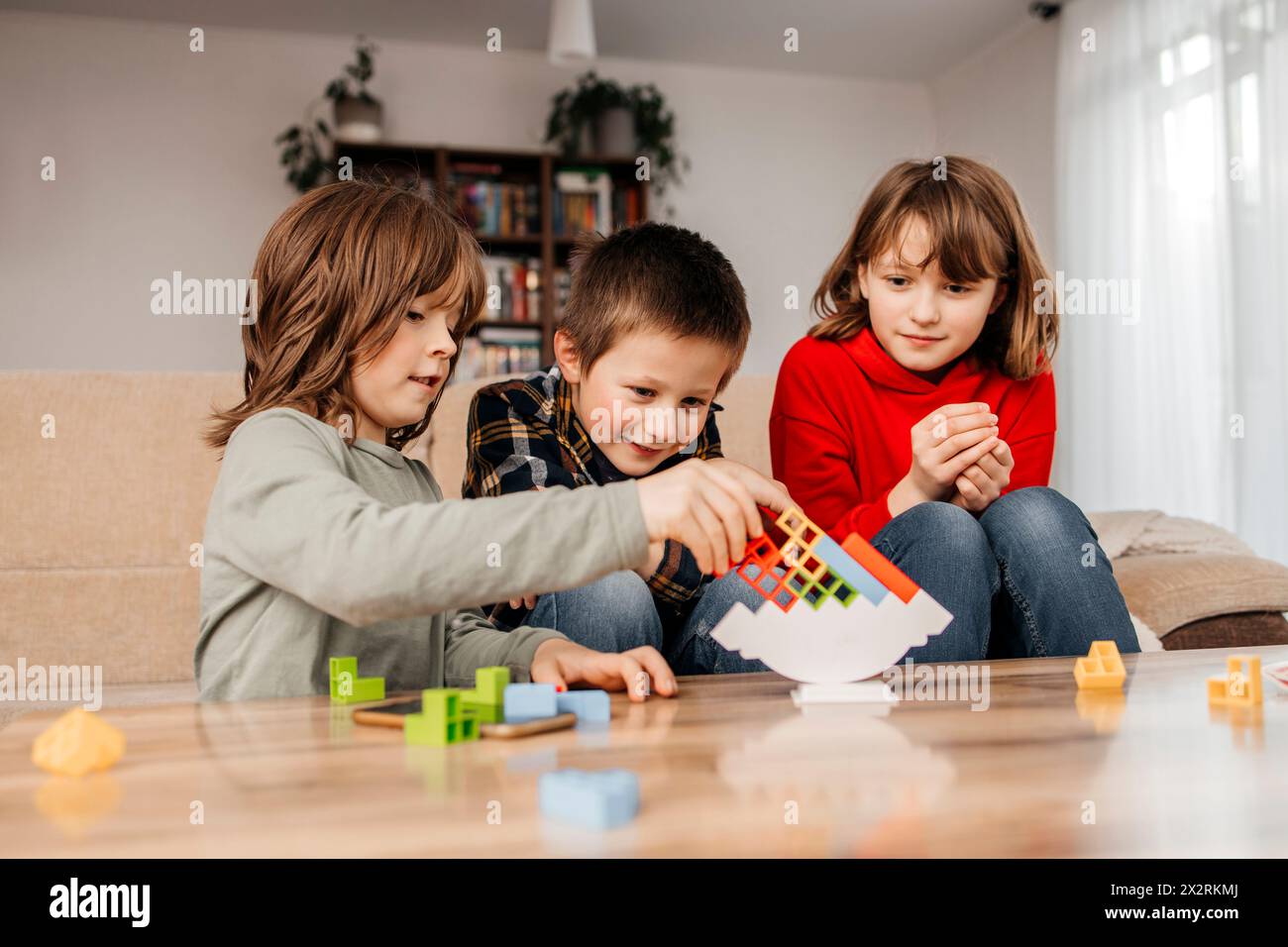 Geschwister stapeln Blöcke und spielen zu Hause Stockfoto