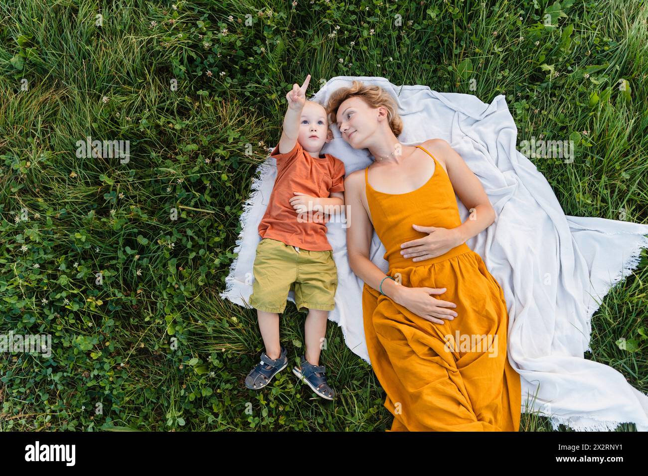 Mutter und Sohn liegen auf einer Decke über Gras auf der Wiese Stockfoto