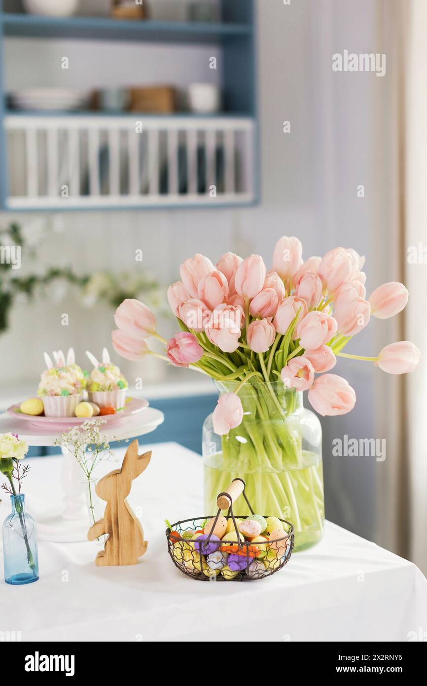 Osterdekoration und pfirsichfarbene Tulpen auf dem Tisch zu Hause Stockfoto