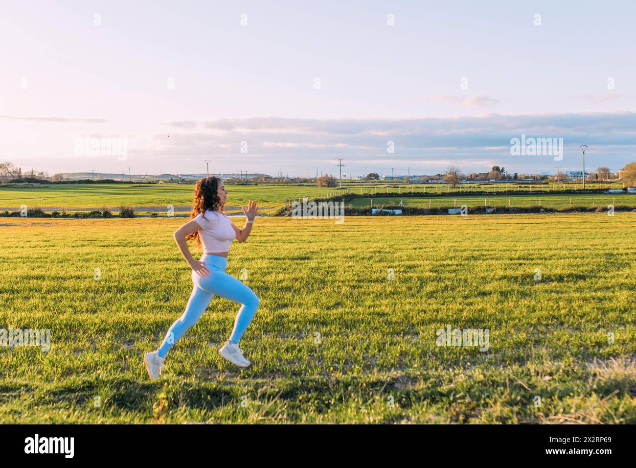Frau sprintet an sonnigem Tag auf der Wiese Stockfoto