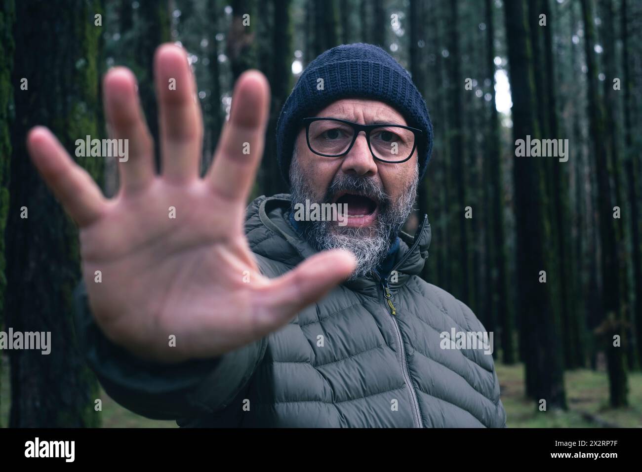 Ein wütender Mann zeigt Stop-Geste im Wald Stockfoto