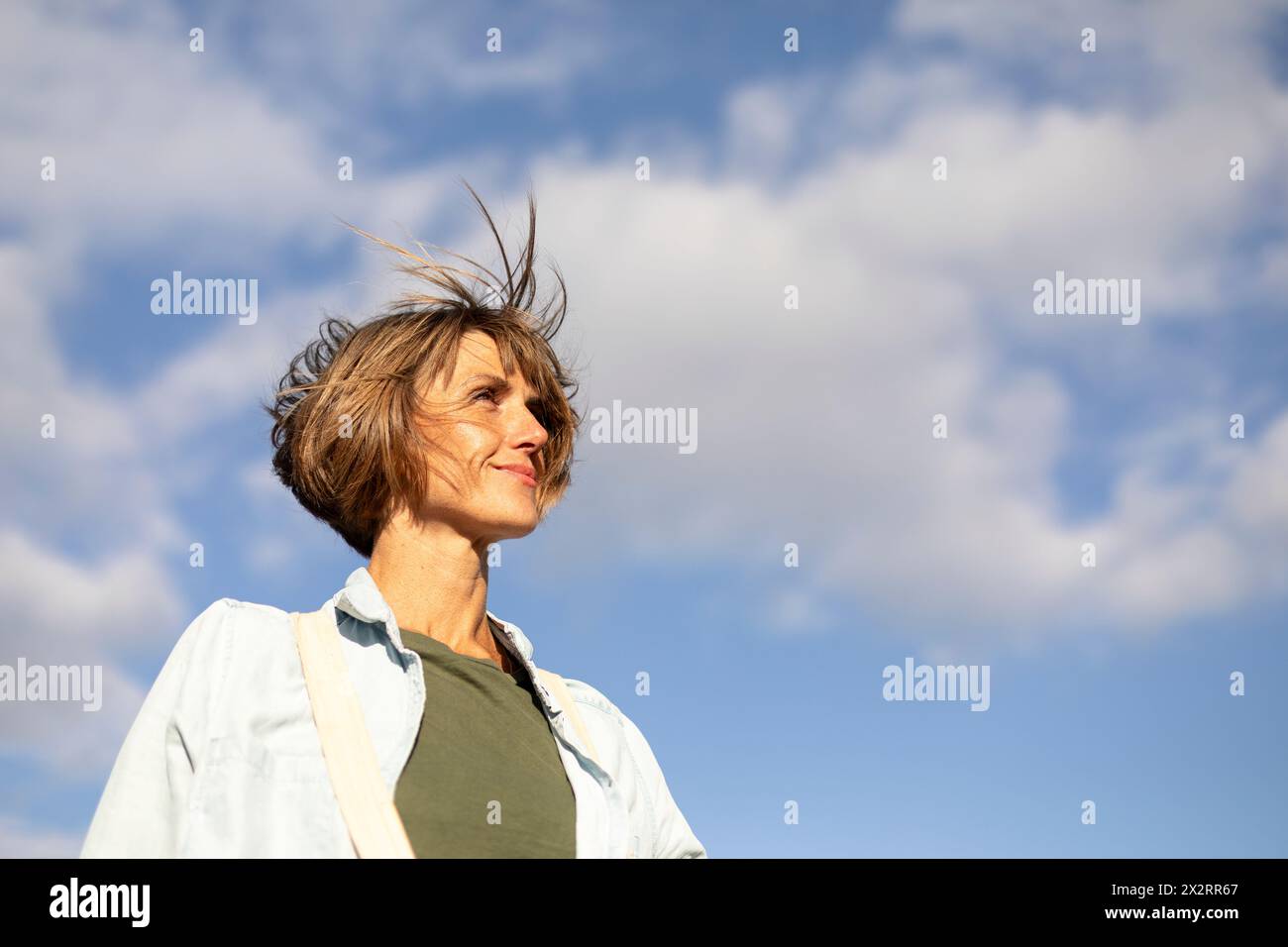 Frau mit kurzen Haaren unter blauem Himmel Stockfoto