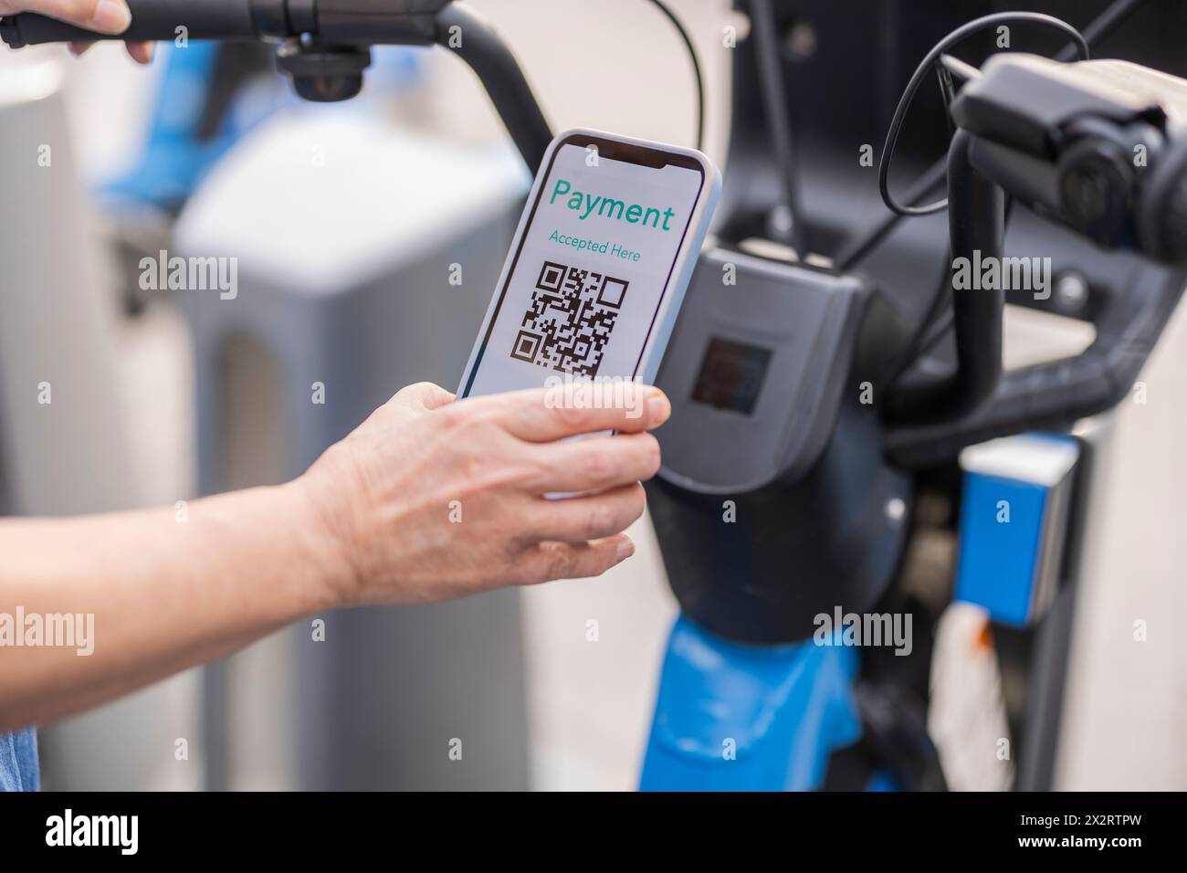 Hände einer Frau, die für Fahrradverleih über das Smartphone bezahlt Stockfoto