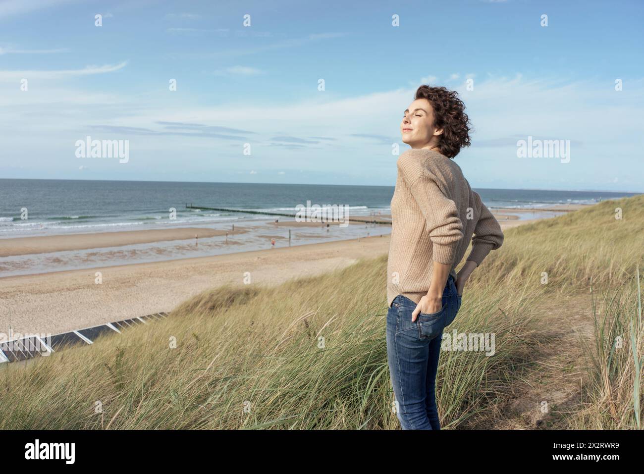 Schöne Frau mit geschlossenen Augen am Strand stehen Stockfoto
