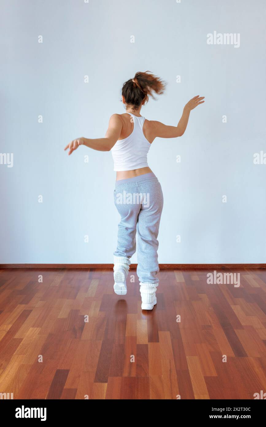 Eine Frau, die Tanz übt, bewegt sich in der Nähe der Wand im Studio Stockfoto
