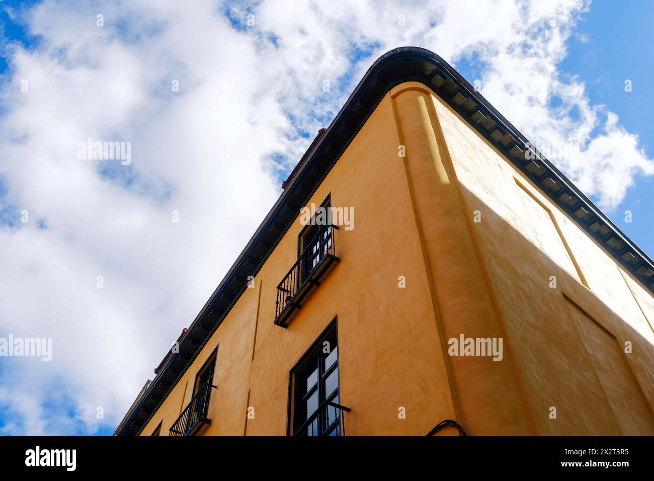 Hohes braunes Gebäude unter blauem bewölktem Himmel Stockfoto