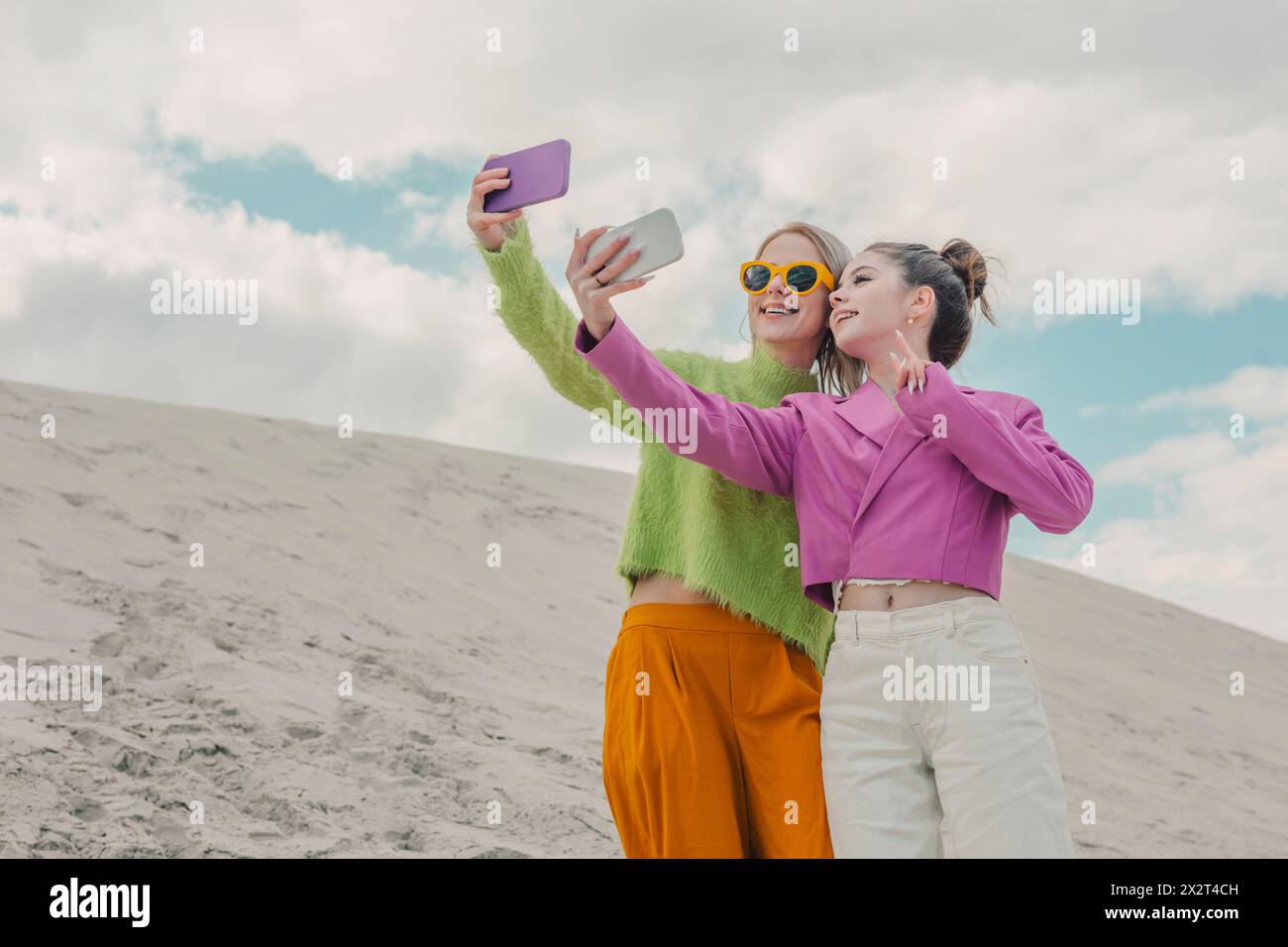 Glückliche Frauen machen Selfie durch Smartphones unter bewölktem Himmel Stockfoto
