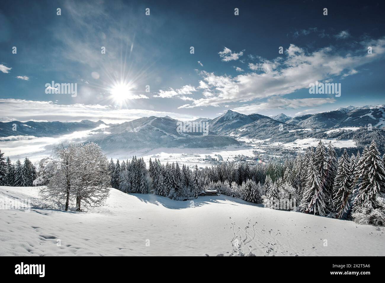 Österreich, Salzburger Land, Altenmarkt im Pongau, Sonne über schneebedeckten Bergen Stockfoto