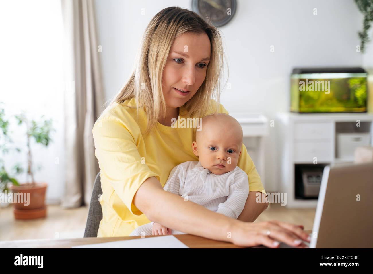 Blonde Geschäftsfrau, die mit ihrem Sohn am Tisch sitzt Stockfoto
