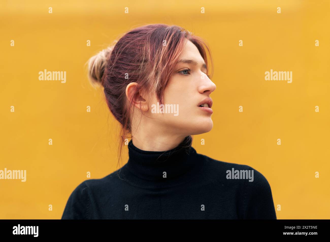 Schöne junge Frau mit gefärbten Haaren auf gelbem Hintergrund Stockfoto