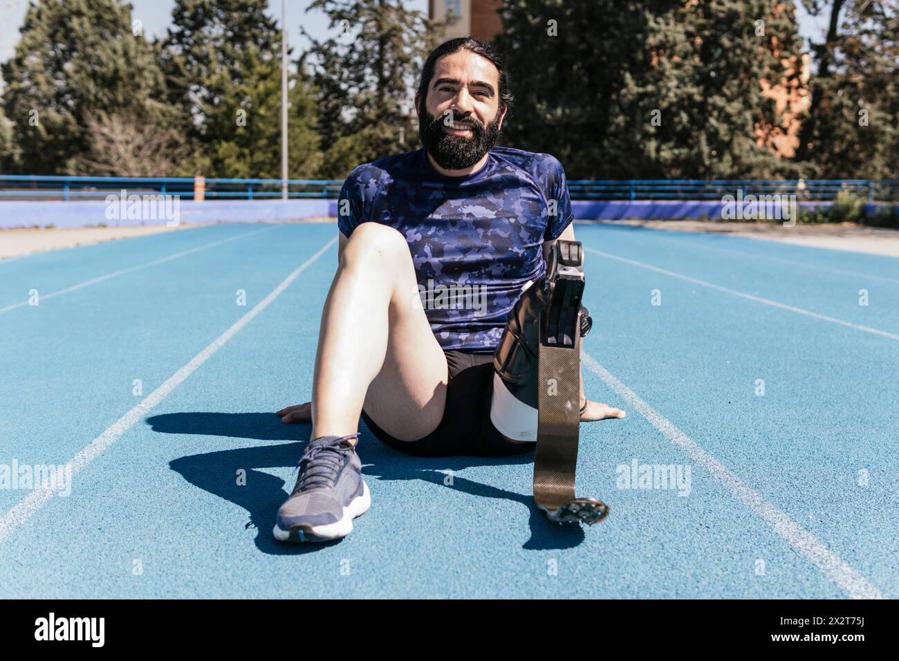 Lächelnder Athlet mit Beinprothetik auf der Sportbahn Stockfoto