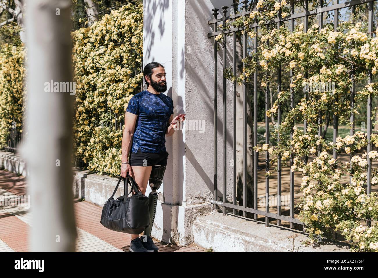 Athlet mit prothetischem Bein am Zaun angelehnt Stockfoto