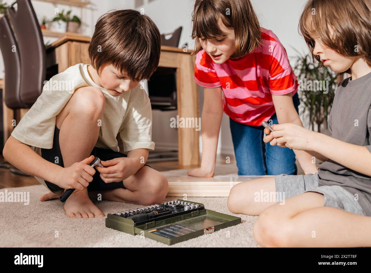 Geschwister mit Handwerkskasten im Wohnzimmer zu Hause Stockfoto
