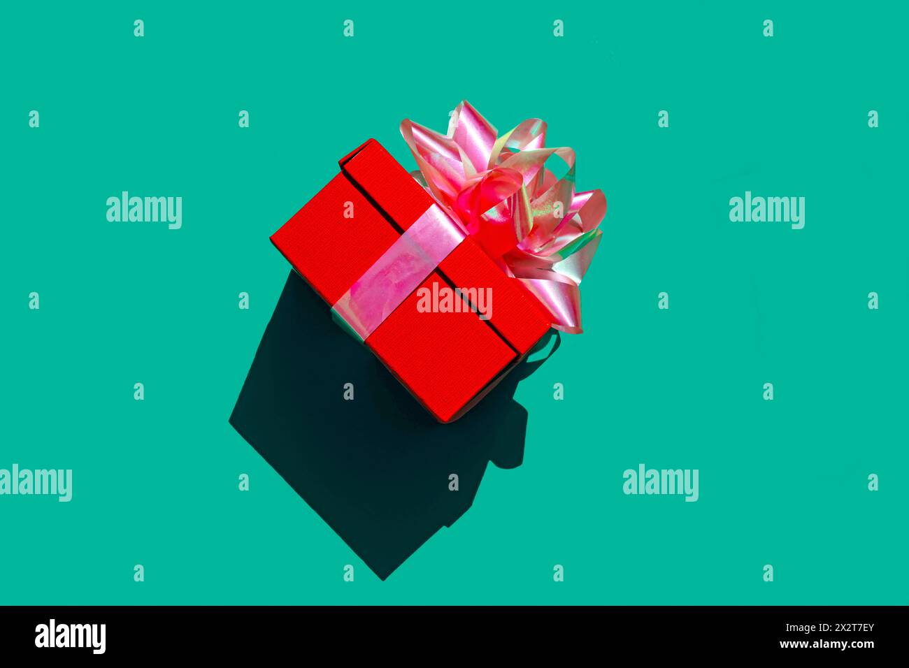 Rote Geschenkbox vor grünem Hintergrund Stockfoto