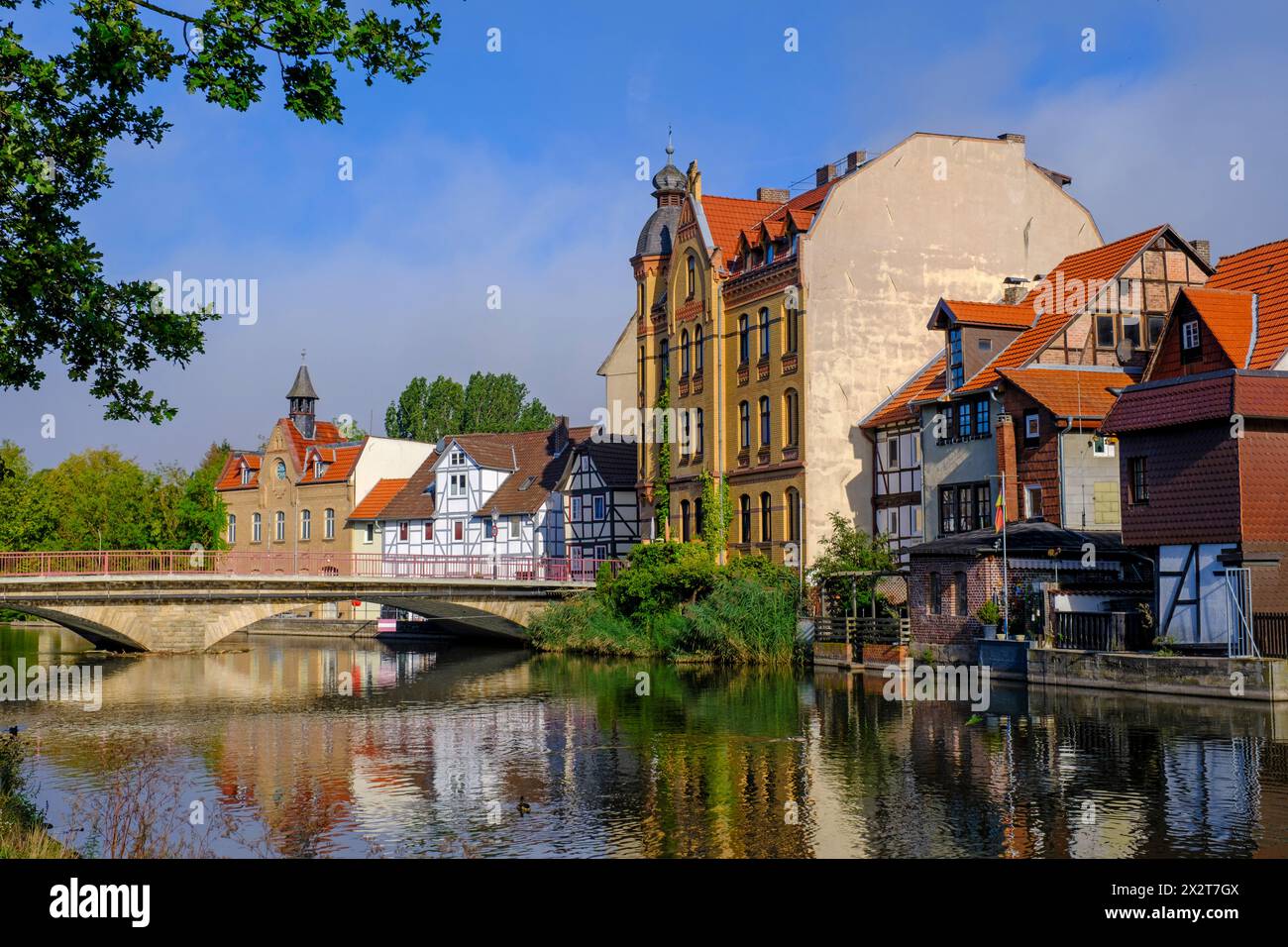 Deutschland, Hessen, Eschwege, historische Häuser entlang der Werra mit Bogenbrücke im Hintergrund Stockfoto