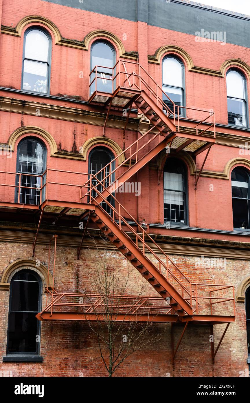 Ein farbenprächtiges, denkmalgeschütztes Gebäude an der Cambie Street mit einer Feuertreppe und Buntziegeln und Farben Stockfoto
