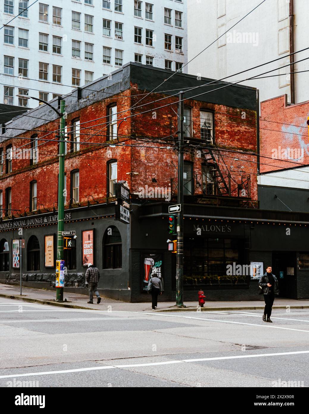 Das alte denkmalgeschützte Gebäude an der Kreuzung von Pender und Seymour Street beherbergt Malone's Taphouse und das Cambie Hostel Stockfoto