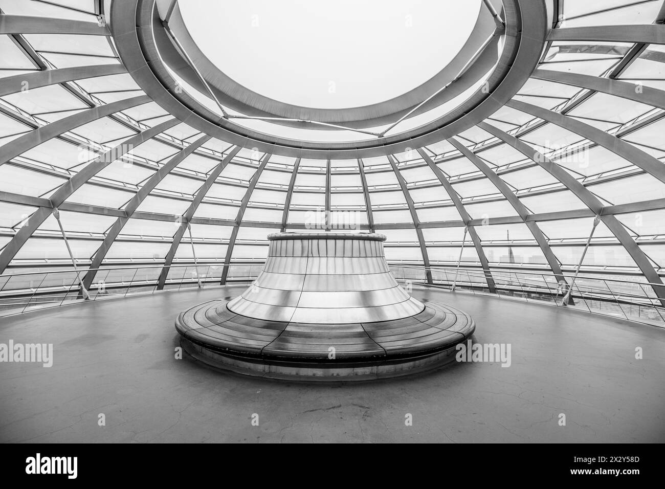 Innenansicht der Reichstagsglaskuppel in Berlin mit dem oberen Teil mit kreisförmiger Bank unter dem Glasdach und Stahlgerüst. Berlin, Deutschland. Schwarzweißbild. Stockfoto