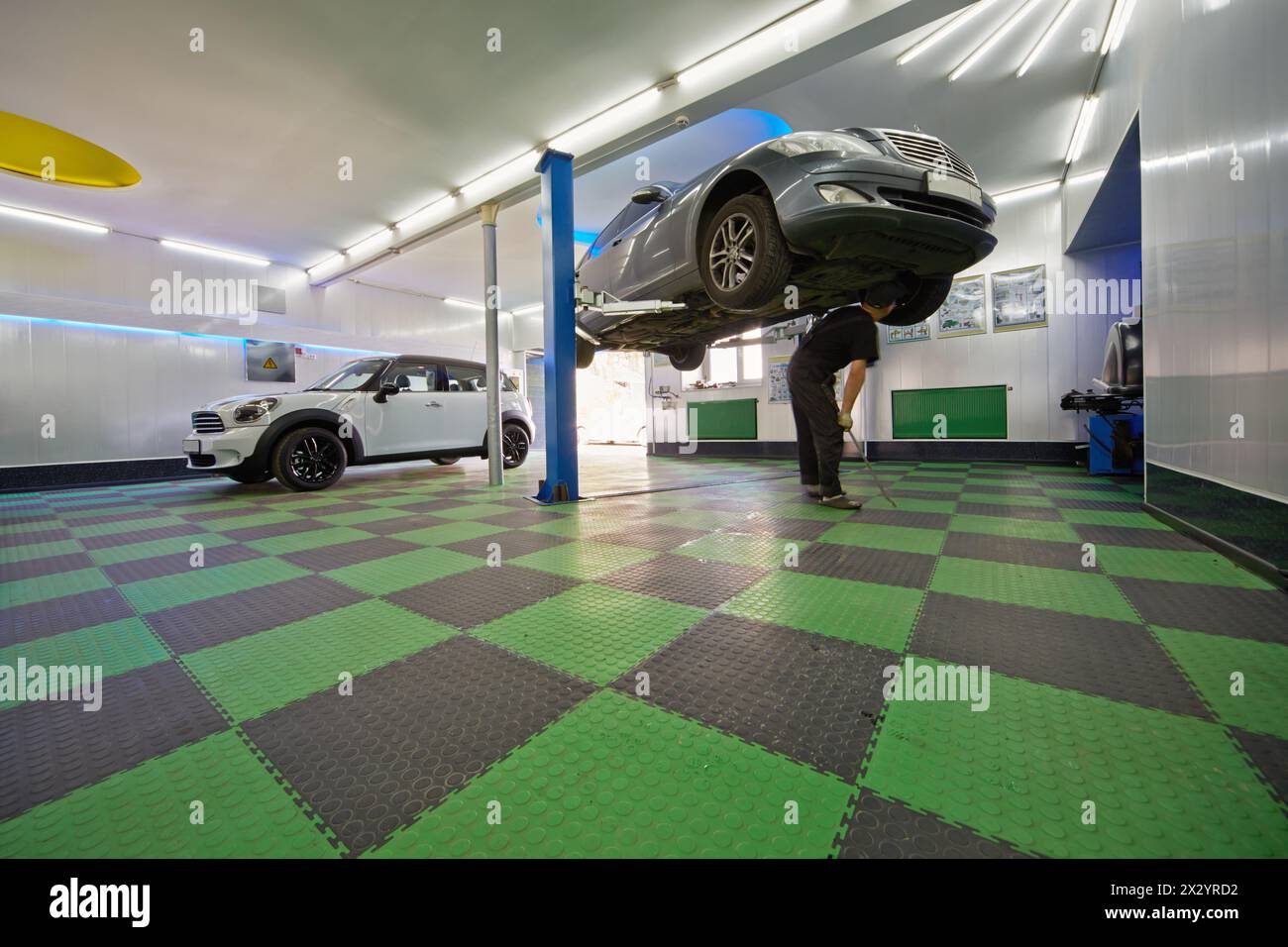 MOSKAU - 21. August: Automechaniker untersucht Fahrzeugboden an der Tankstelle Avtostandart, 21. August 2012, Moskau, Russland. Stockfoto