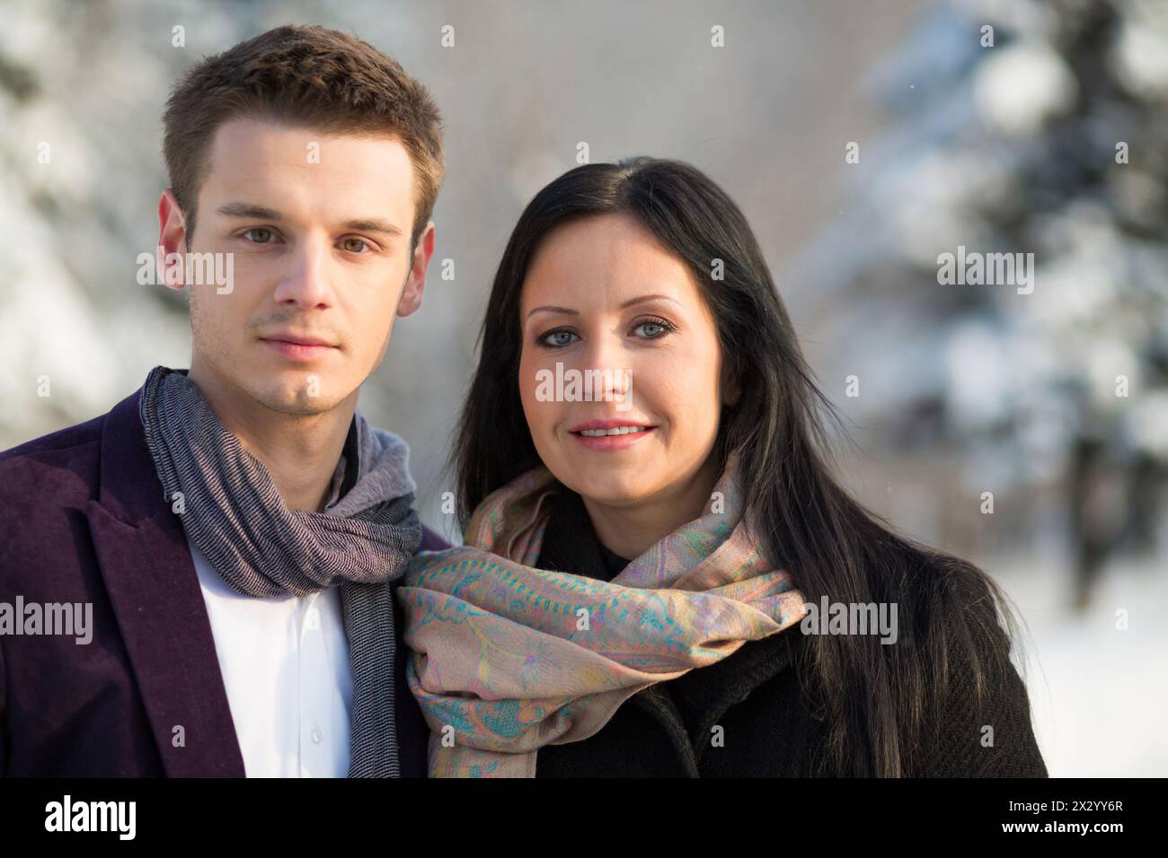 Mann und Frau stehen im Winter draußen in Tüchern, konzentrieren sich auf eine Frau. Stockfoto