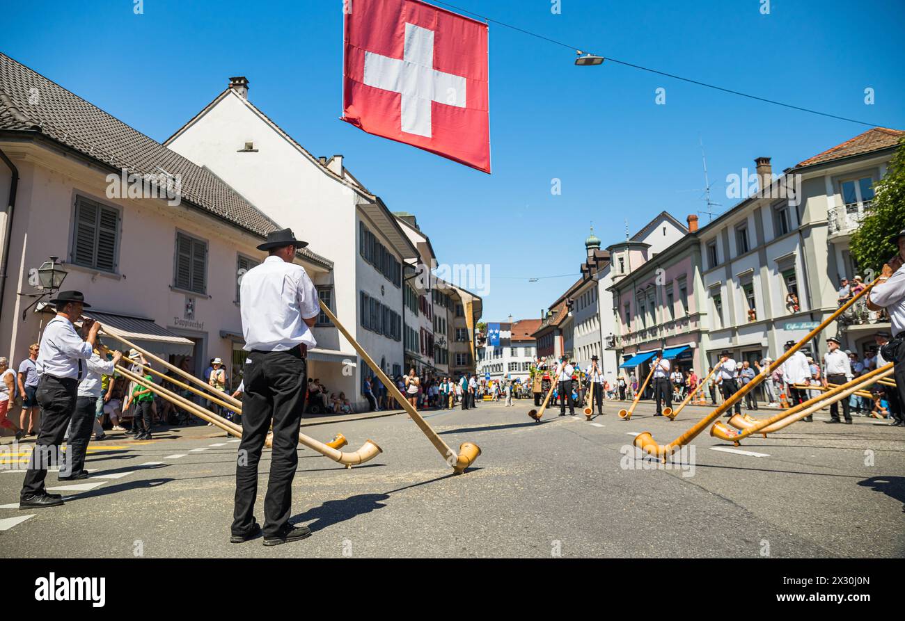 Einige Alphornbläser stehen im Kreis und spielen das Schweizer Traditionsinstrument Alphorn. (Bad Zurzach, Schweiz, 12.06.2022) Stockfoto