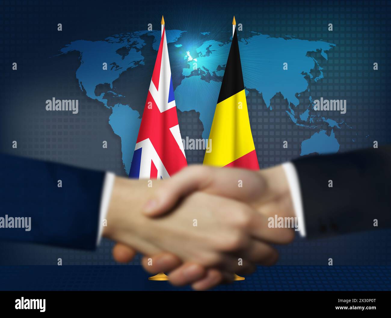 Zwei Menschen schütteln sich die Hände vor belgischen und britischen Flaggen Stockfoto