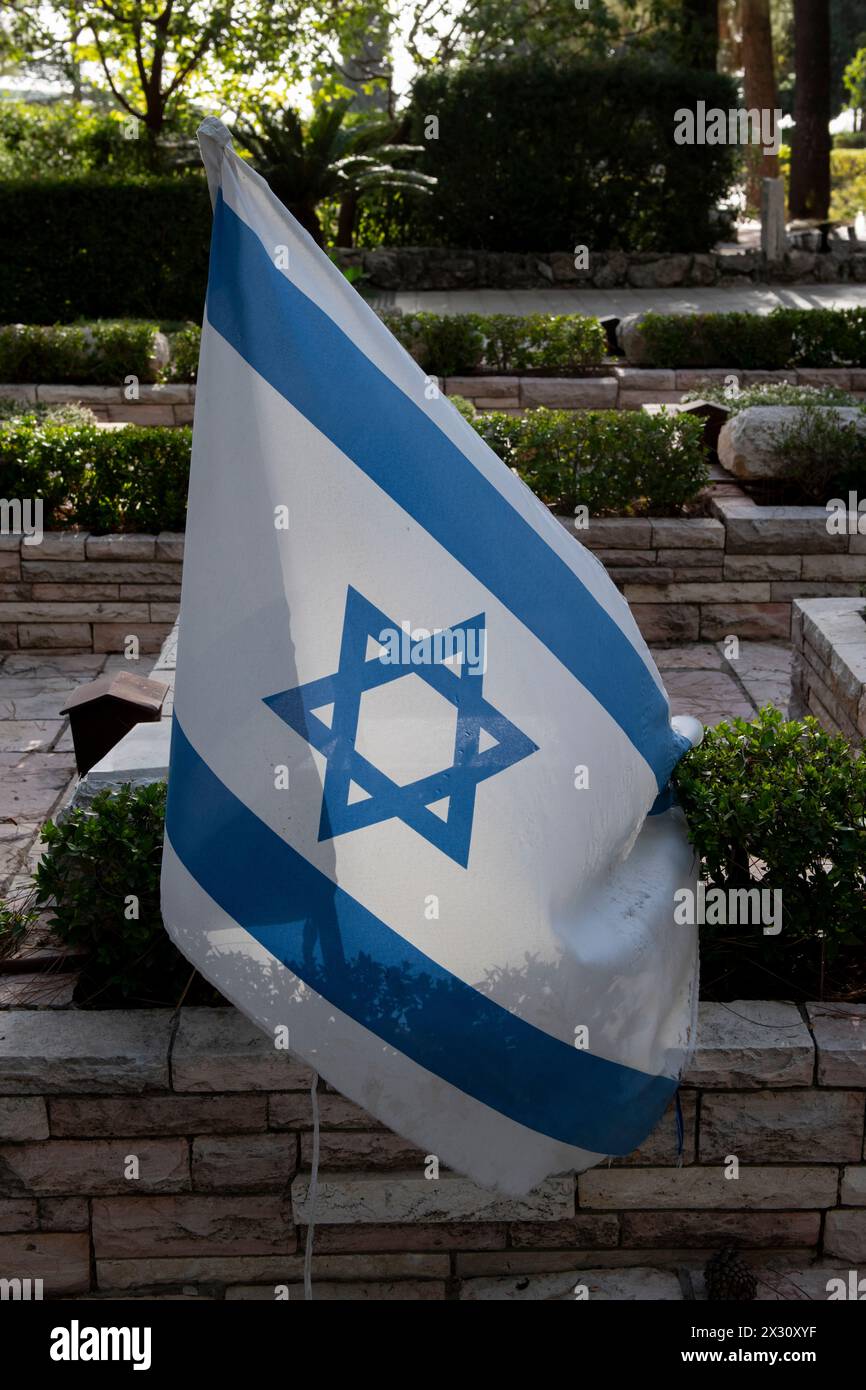 Eine einzige israelische Flagge auf dem Grab eines gefallenen israelischen Soldaten auf dem Militärfriedhof Mount Herzl in Jerusalem, Israel. Stockfoto
